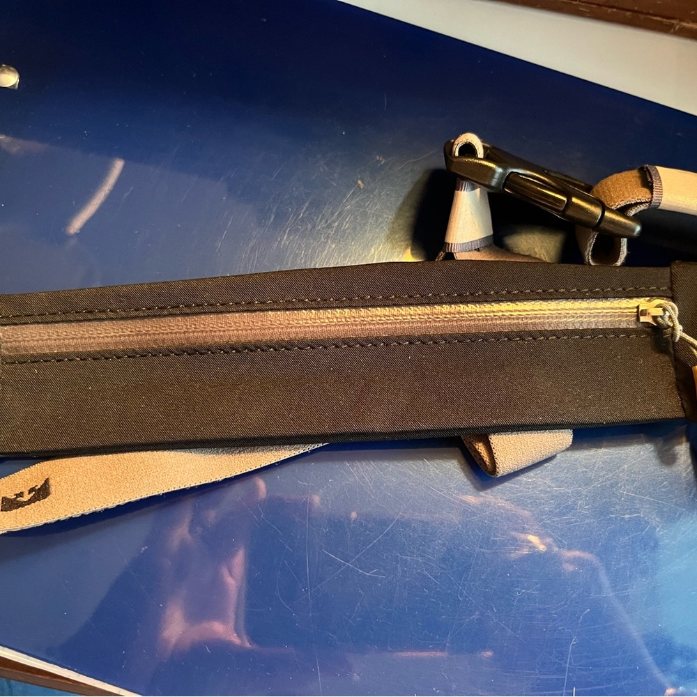 Black thin storage waistpack by Nathan for walking or running